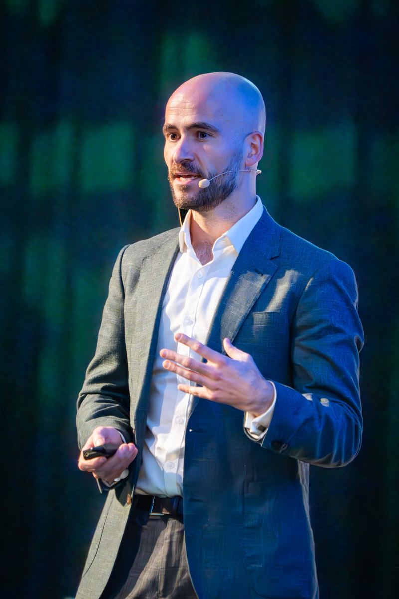 Dr Joep van Agteren, wellbeing scientist and workplace wellbeing expert, presenting on stage